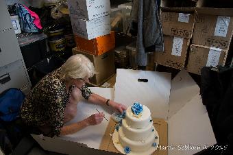 Carol finishes the cake in the stock cupboard!